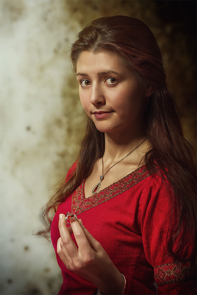 Portrait einer Frau in rotem Kleid einen Ring betrachtend