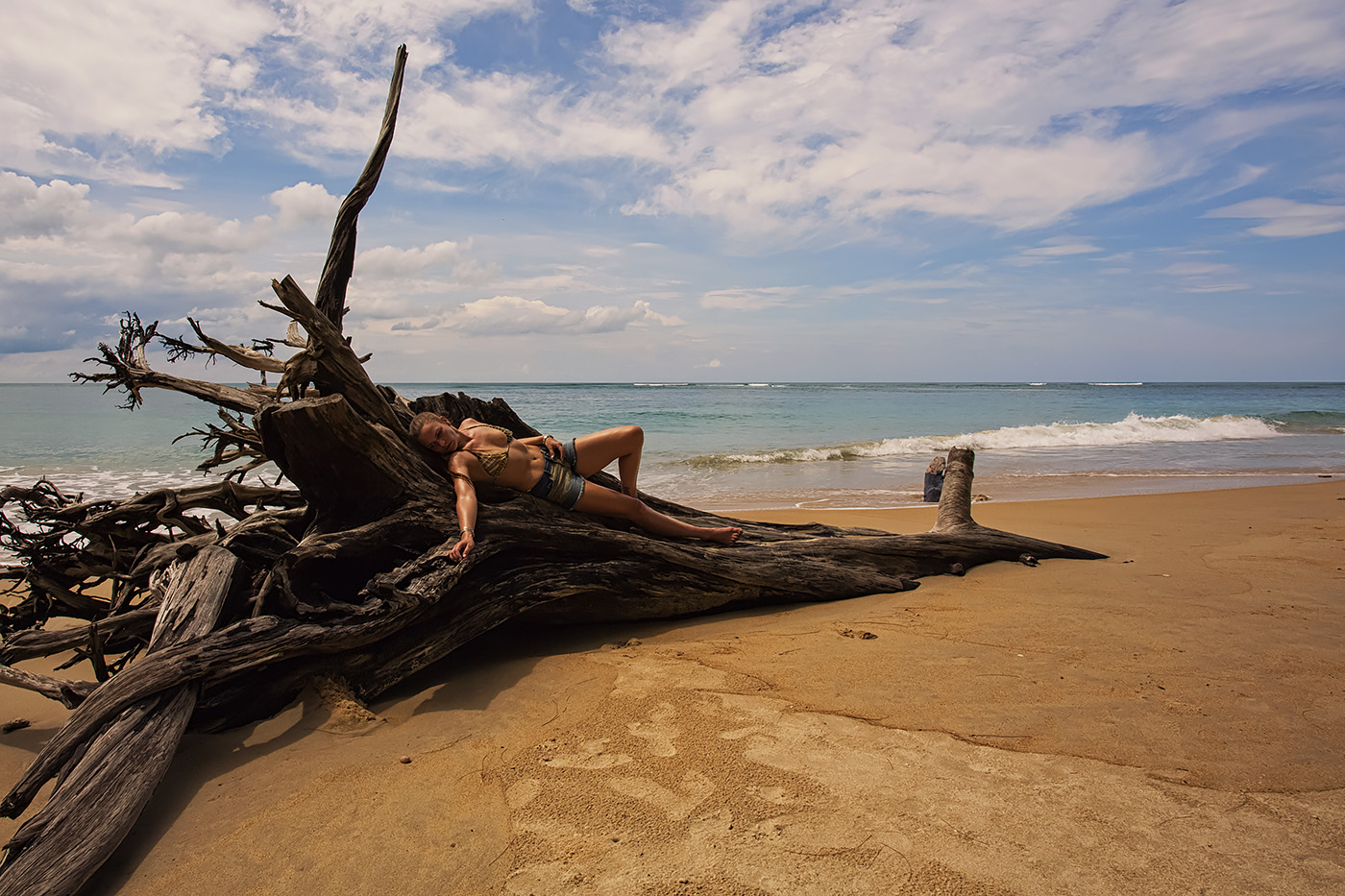 Frau liegt auf Baum an Strand in Thailand